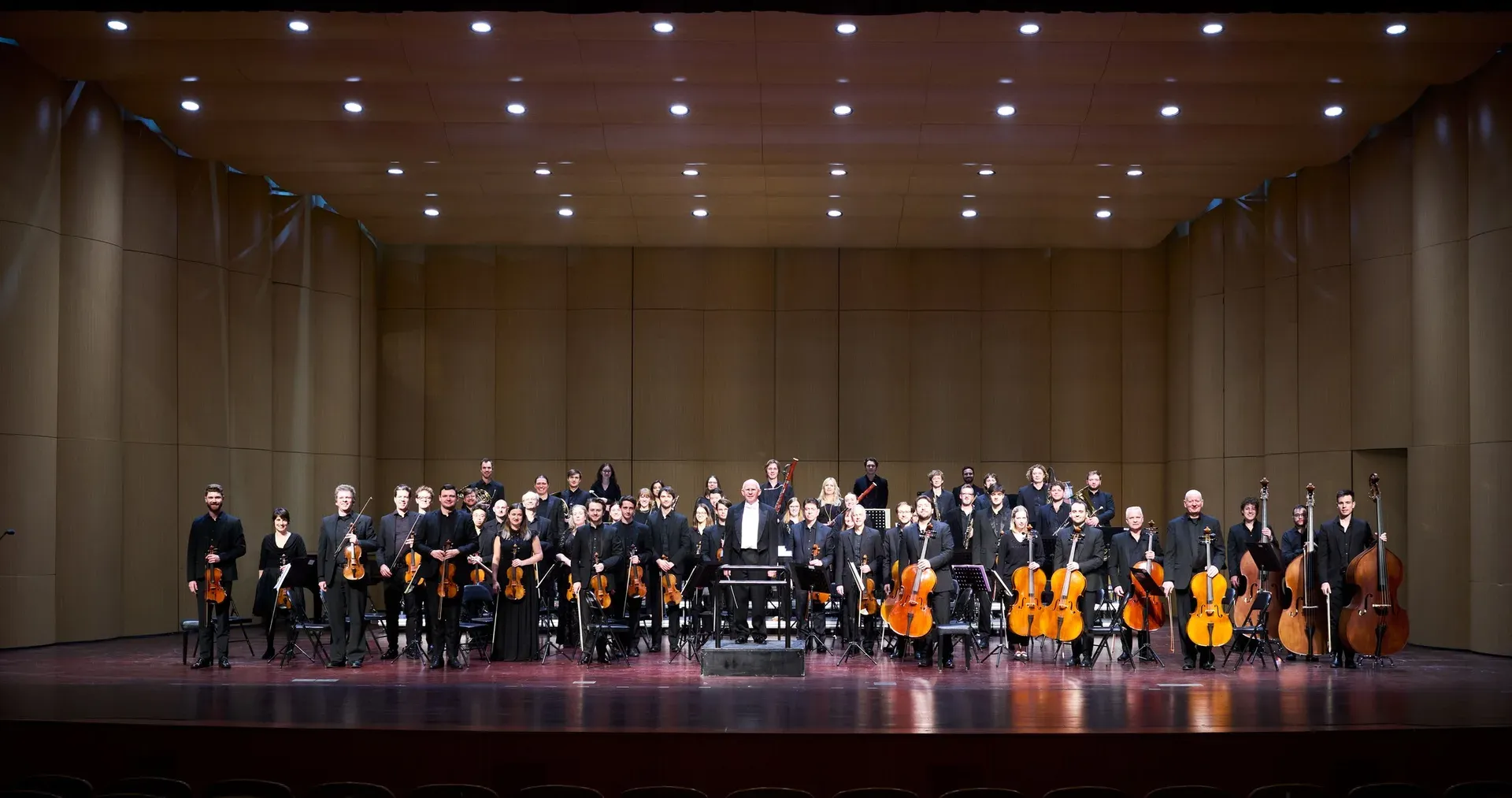 The orchestra on stage in a concert hall in Hangzhou, China, standing to take a bow.
